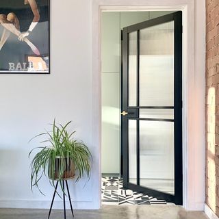glass door with white wall and plants