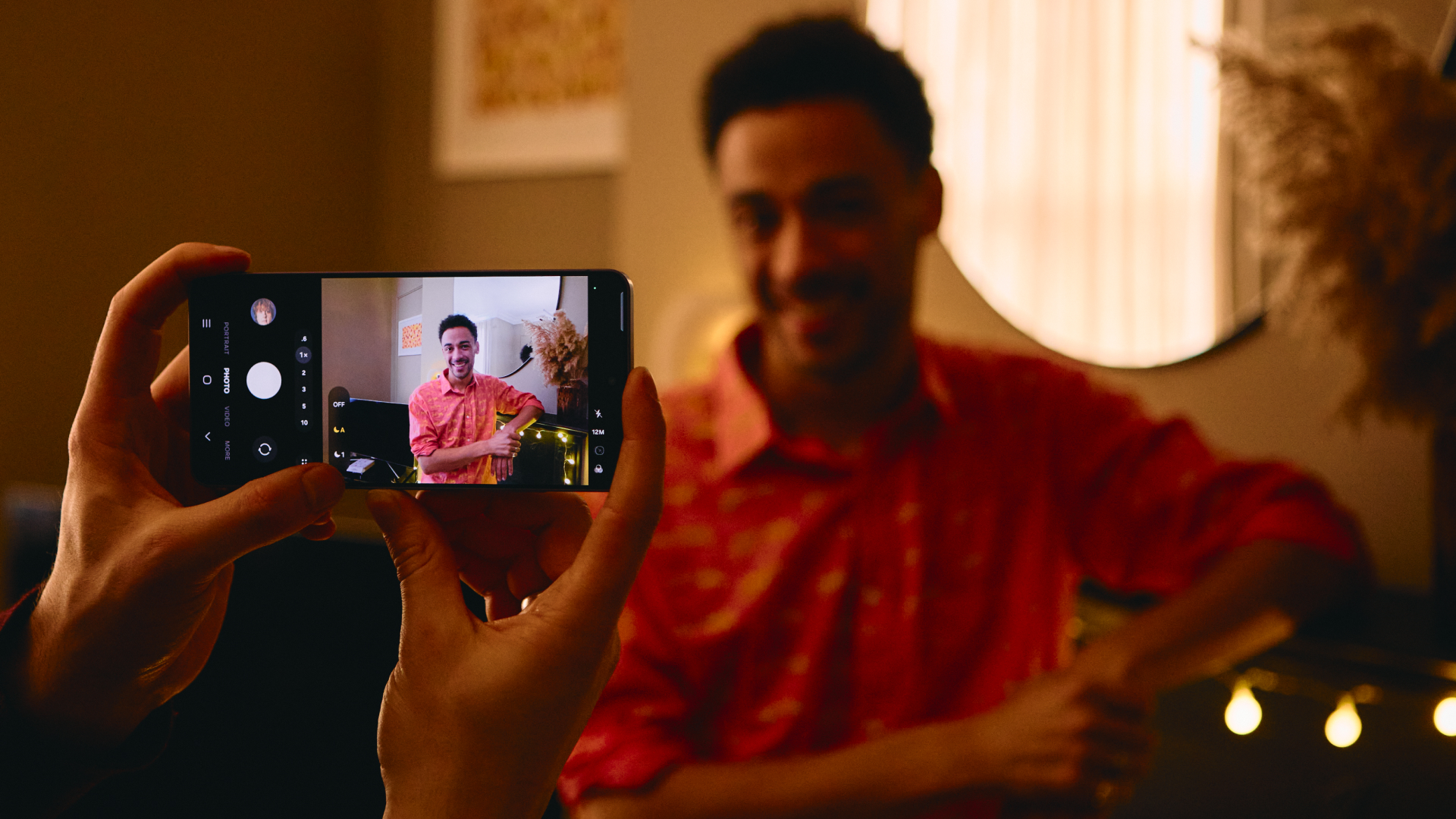 A person takes a photo in low light using the Samsung Galaxy S26 Ultra