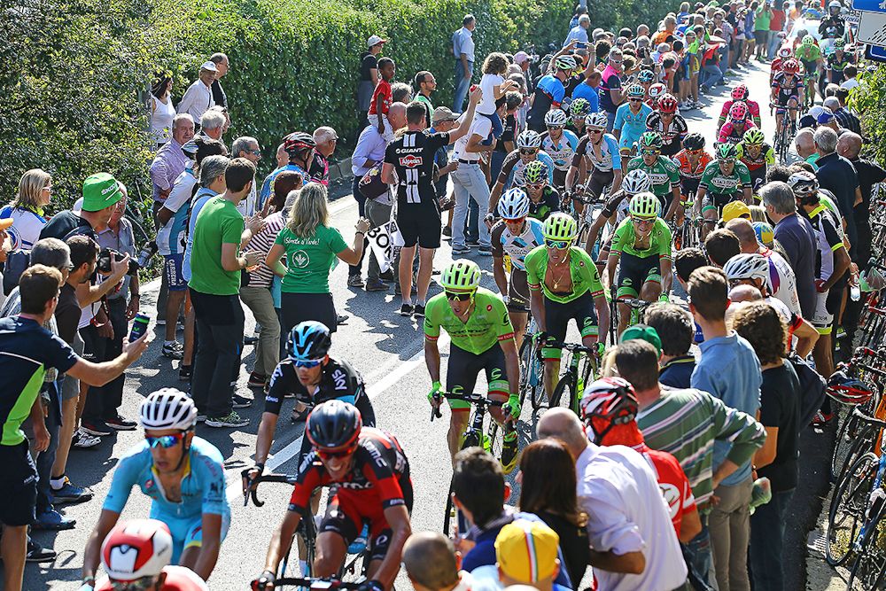 Spectators line the Milano-Torino route as the peloton rides through