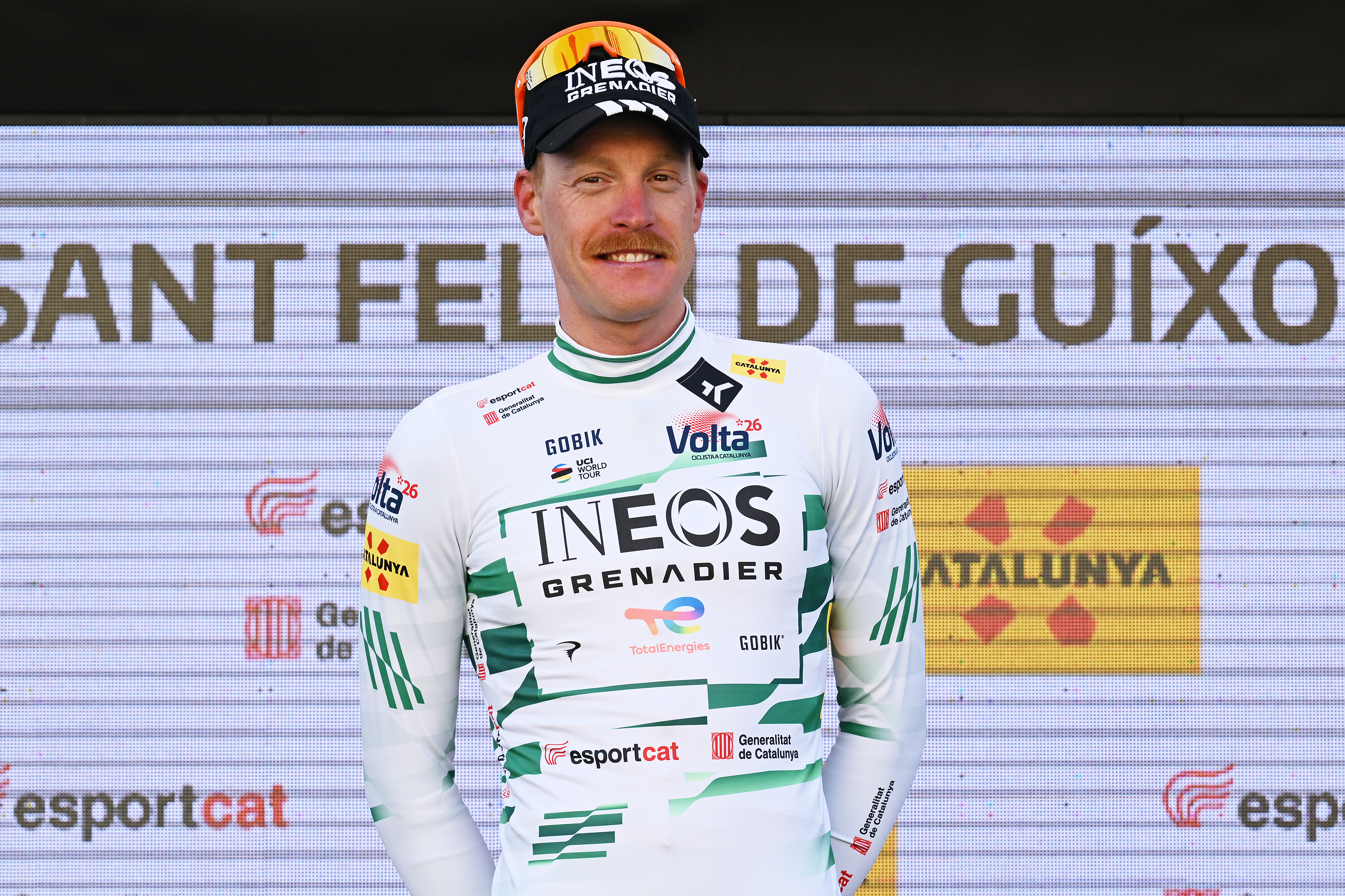 Dorian Godon en el podio de la Volta a Catalunya con el maillot de líder blanco y verde oscuro tras ganar la 1ª etapa de la carrera de 2026.
