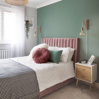 bedroom with green painted feature wall and pink velvet upholstered bed