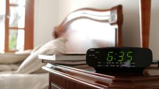 An alarm clock by a bed
