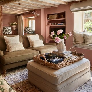 country cottage pink living room with pale green sofa, window seat and ceiling beams