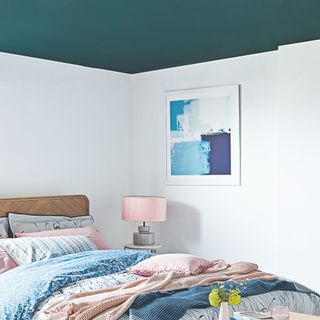 A bedroom with white walls and a teal ceiling