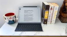 reMarkable 2 in keyboard folio on a table with a cup and books