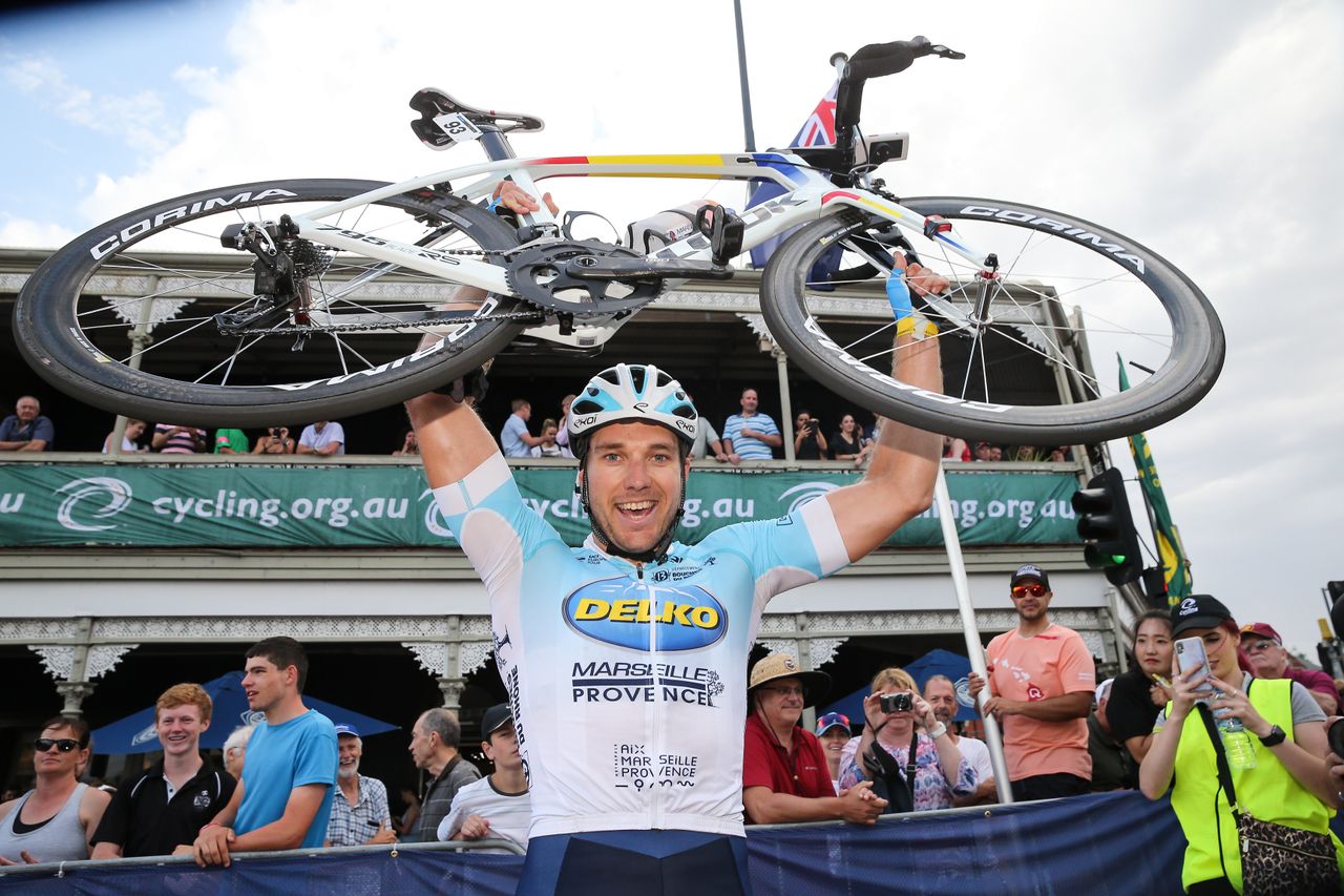 A happy Brenton Jones lifts his bike above his head
