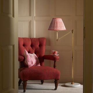 a red chair and floor lamp in a living room