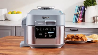 Ninja Speedi multicooker and air fryer on wooden countertop with cookbooks in background