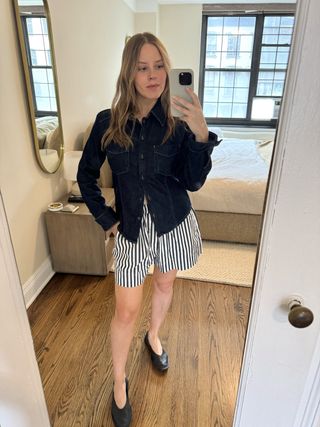 Nikki Chwatt wears a denim shirt, navy striped shorts, and black ballet flats.