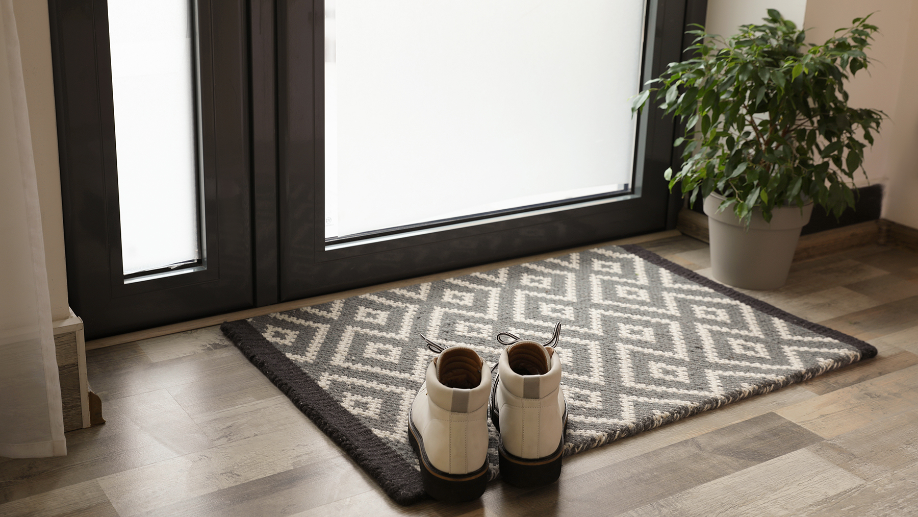 Shoes on patterned doormat in hallway