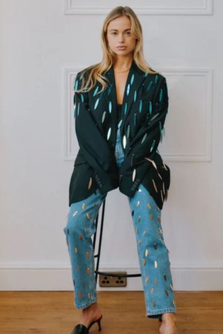 party outfits woman wearing blazer and jeans with leaf-shaped sparkly sequins hanging off