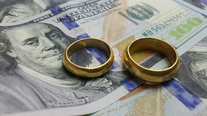 wedding rings laying on money