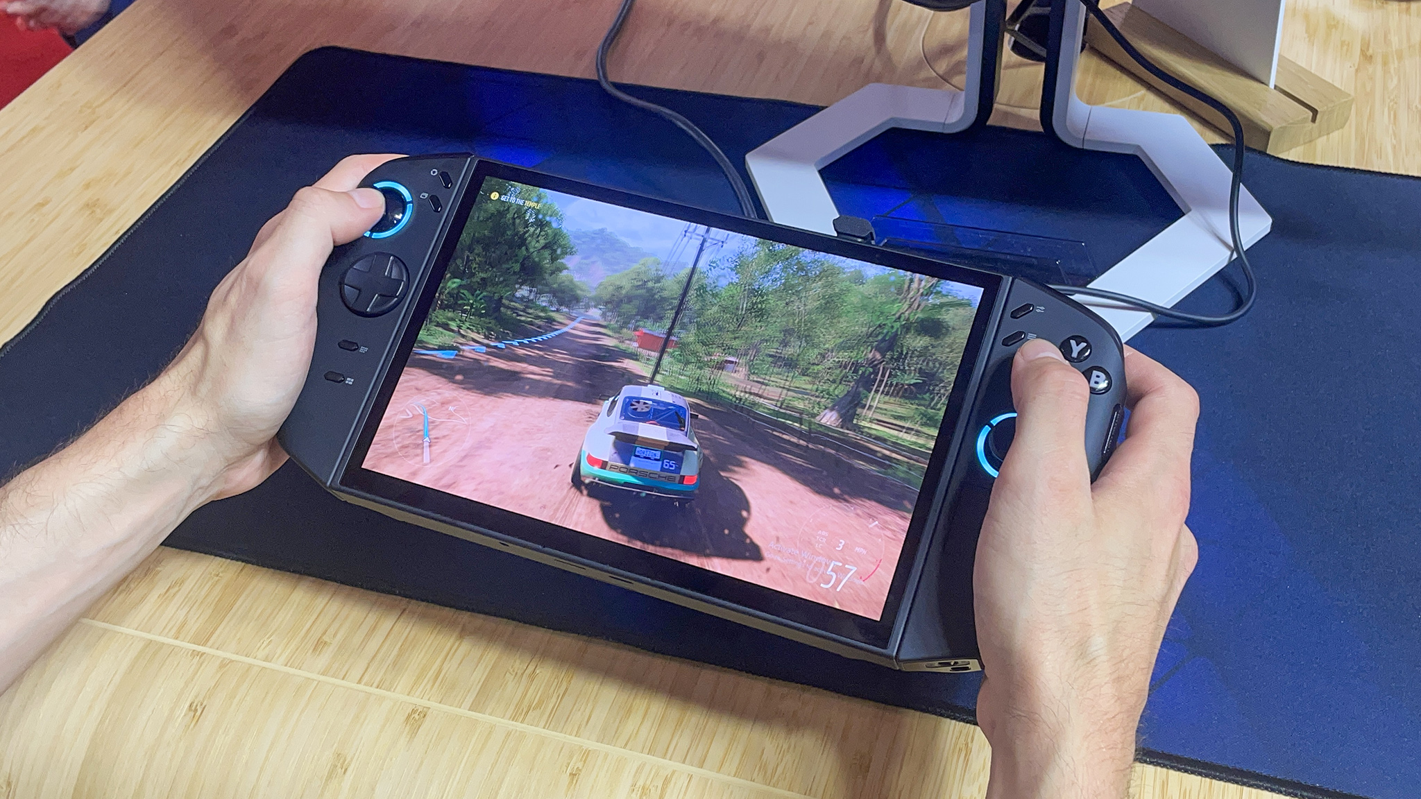 Two hands holding the Lenovo Legion Go 2 and a racing game on the screen. 