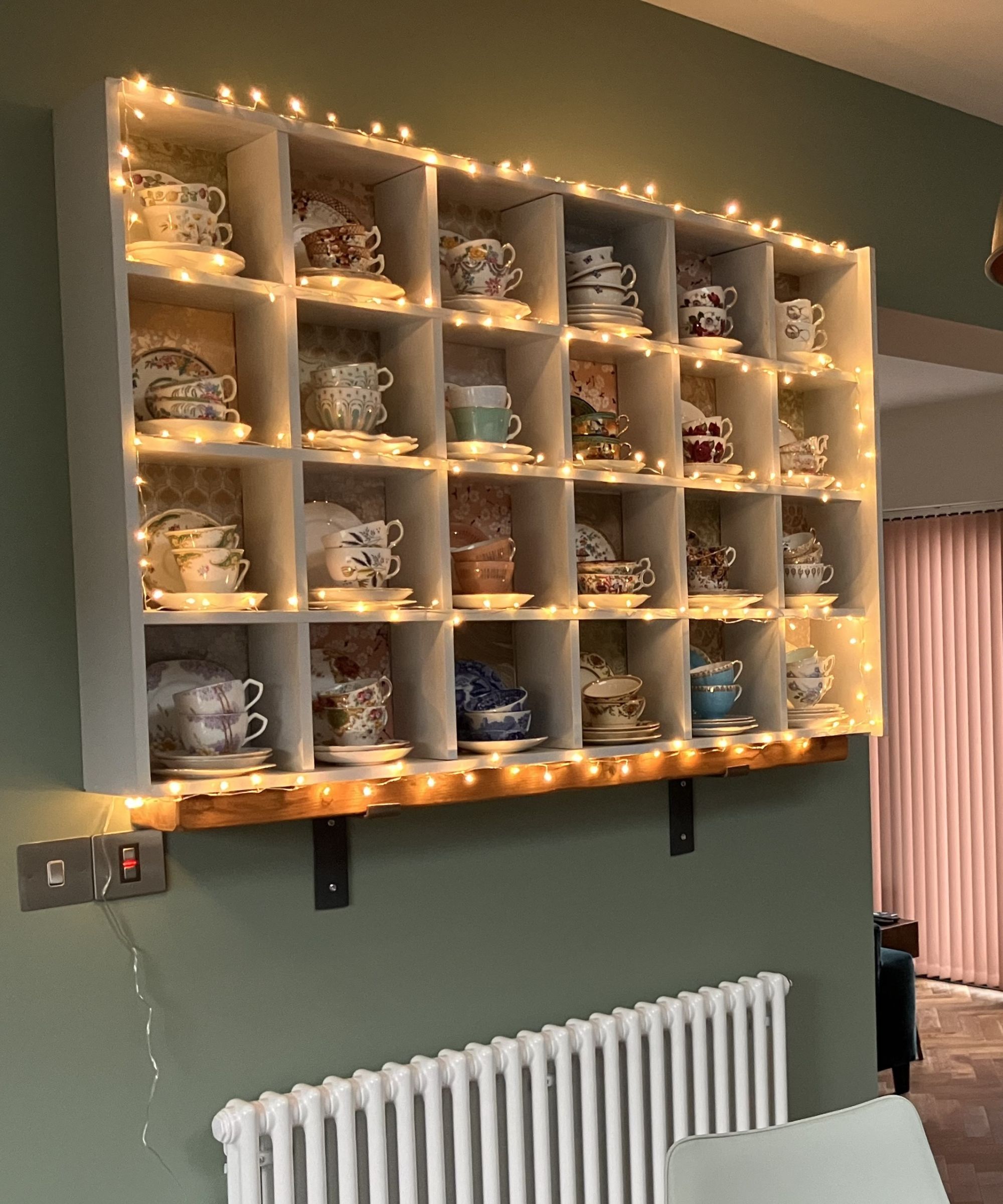 Kitchen shelves draped with warm glowing fairy lights
