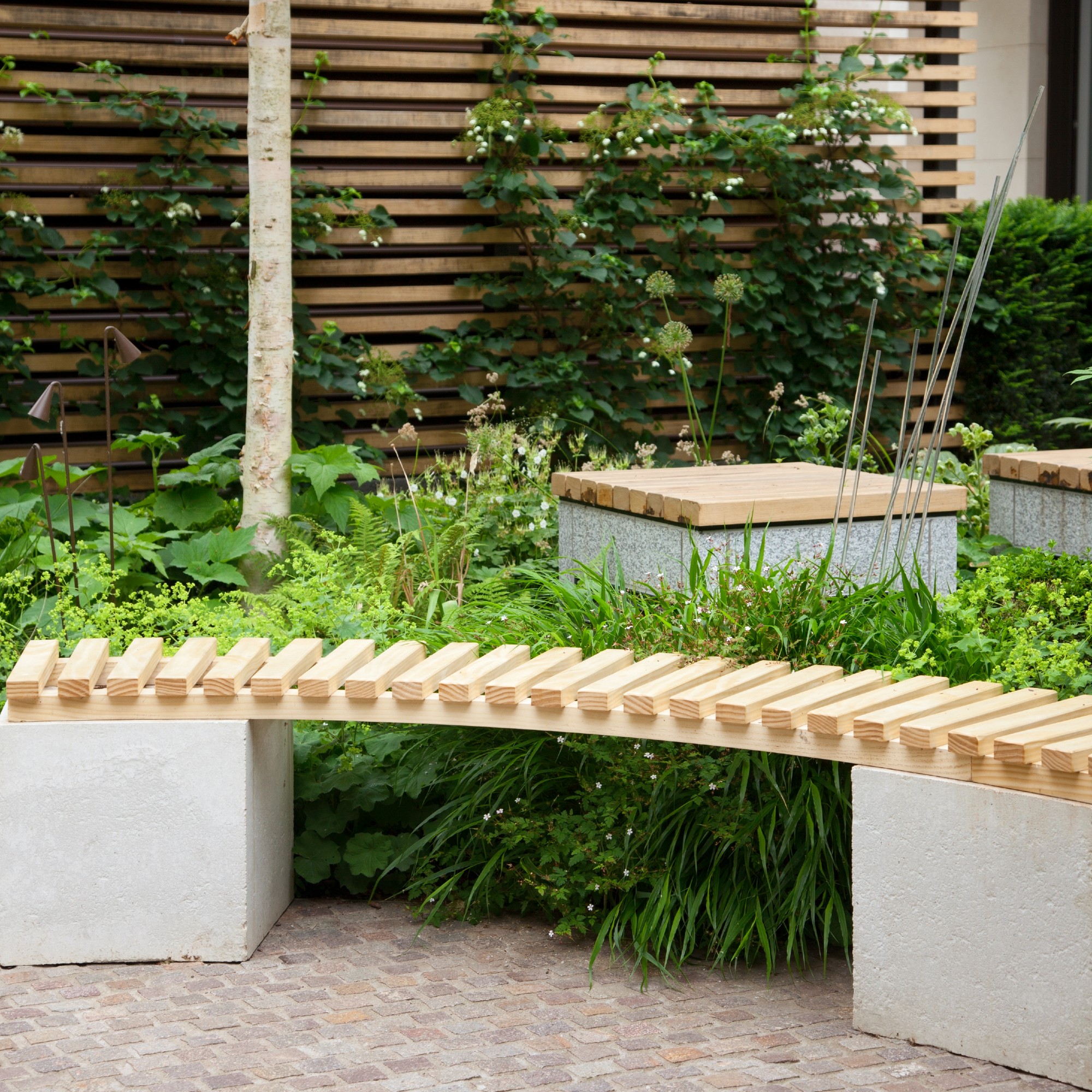 A garden with a built-in wooden-slat bench