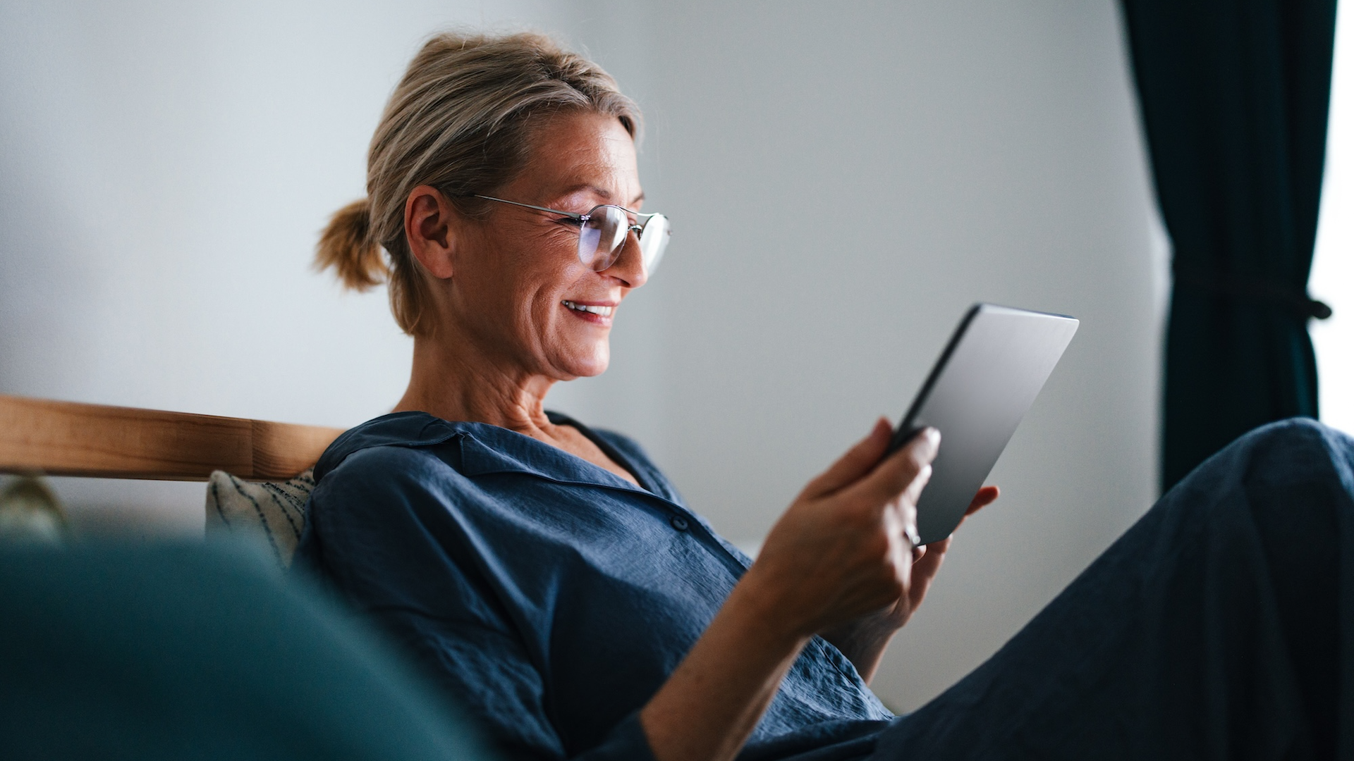 Woman looking at tablet on bed