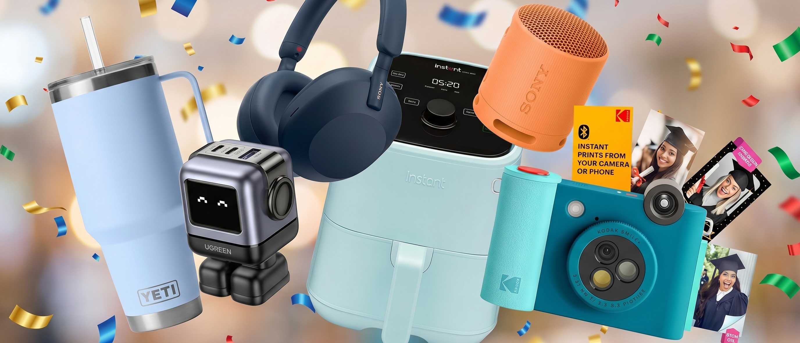 A Kodak instant print camera, charging dock, Yeti cup, Sony headphones and speaker all against a blurred background with confetti floating around