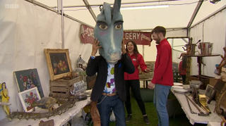 Antiques expert Gary Pe tries on a donkey head in Bargain Hunt