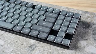 A black Keychron K13 Max wireless keyboard with gray and orange keycaps