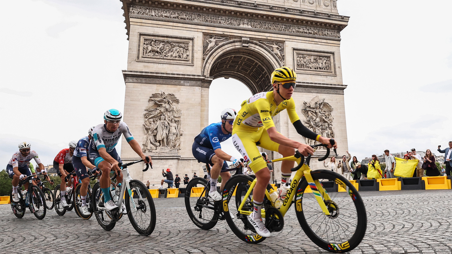 2025 Tour de France yellow jersey winner Tadej Pogacar leads the peloton through Paris in front of the Arc de Triomphe during the final stage/