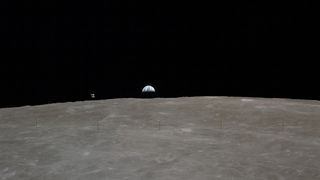 Across the lunar horizon, Earth rises and the Apollo 16 Command and Service Modules, known as "Casper," floats.