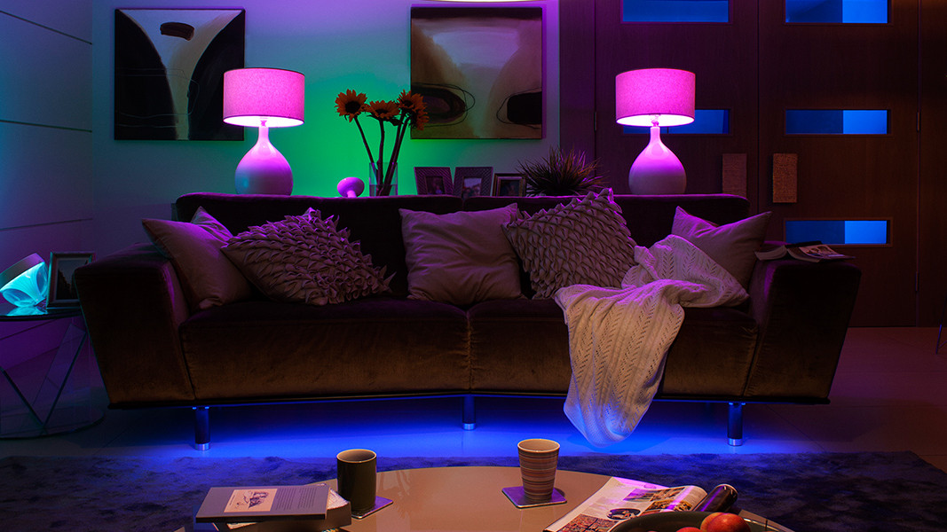 Smarta LIFX-lampor lyser upp ett vardagsrum i lila och gröna toner.