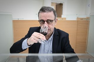 Pierre Hurmic, mayor of Bordeaux, smells a glass of red wine
