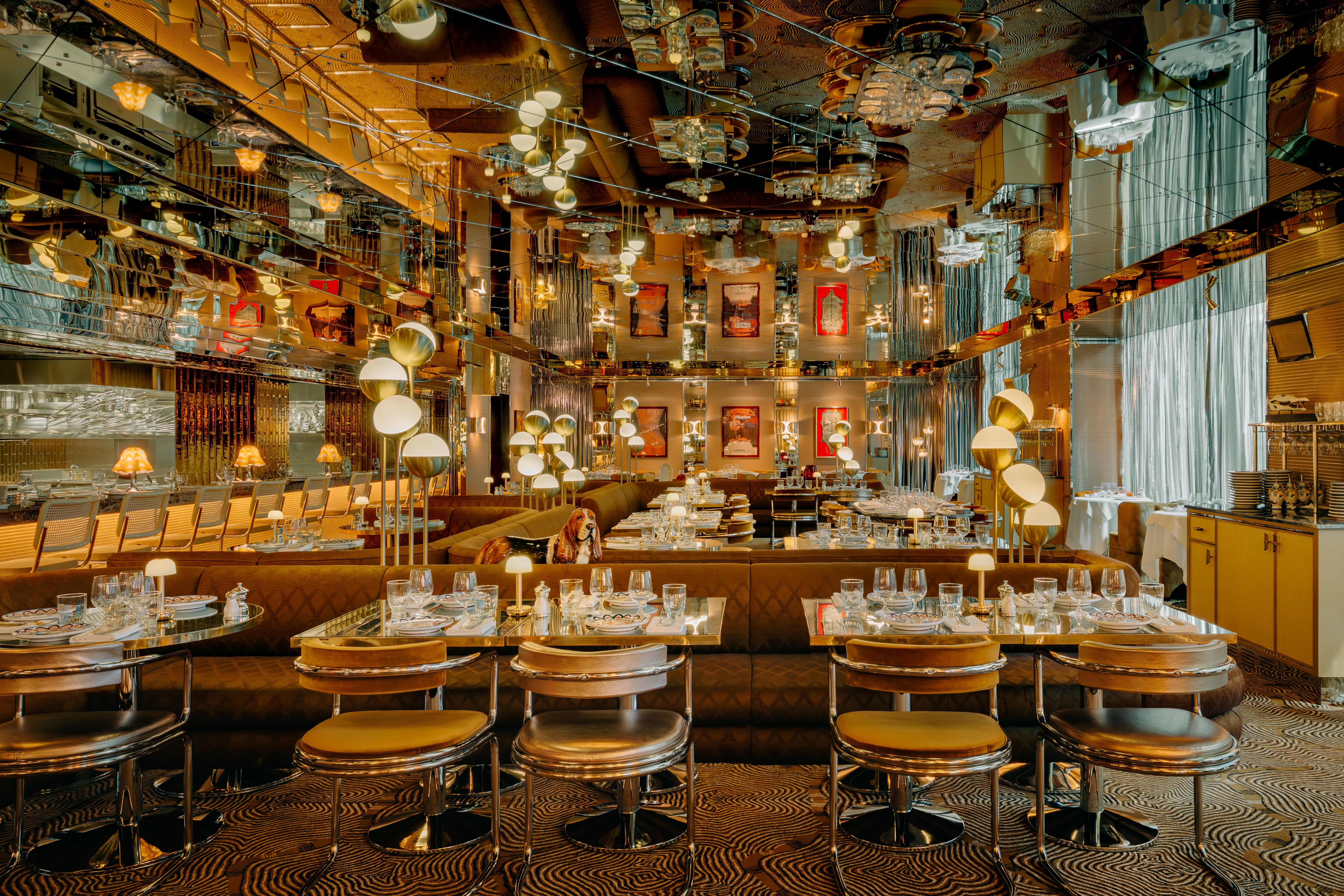 A dining area with a ceiling made entirely of mirrors and reflecting lots of gleaming light fixtures