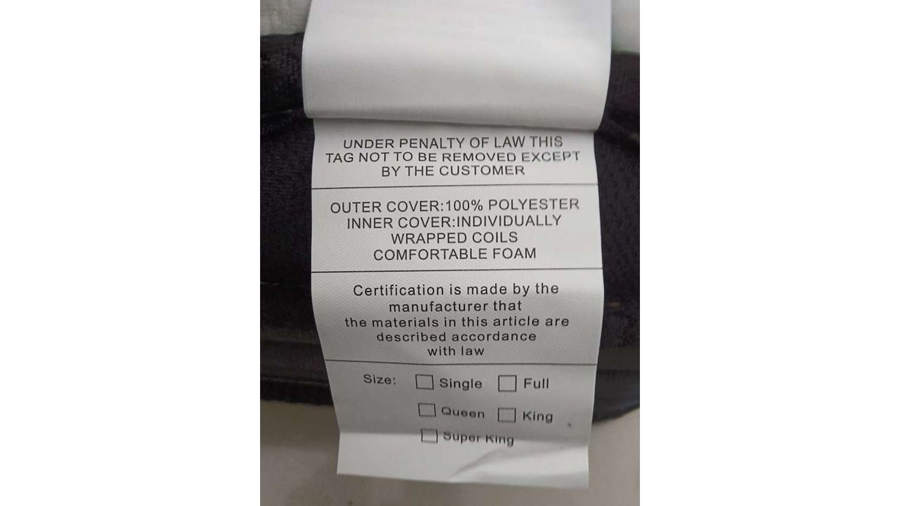 A white label on the side of a Crayan mattress. The label has information about the content and size of the mattress