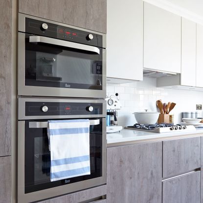 kitchen with oven and hob built into wall alongside countertops