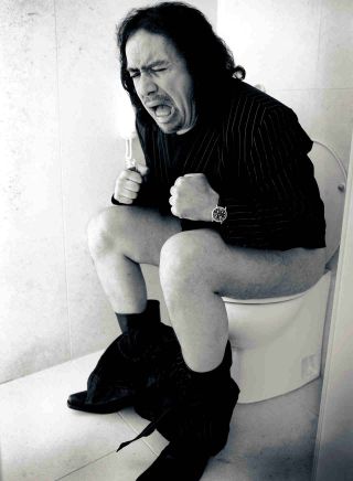 Gene Simmons posing for a photograph on the toilet in 2004