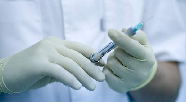 doctor holding syringe needle