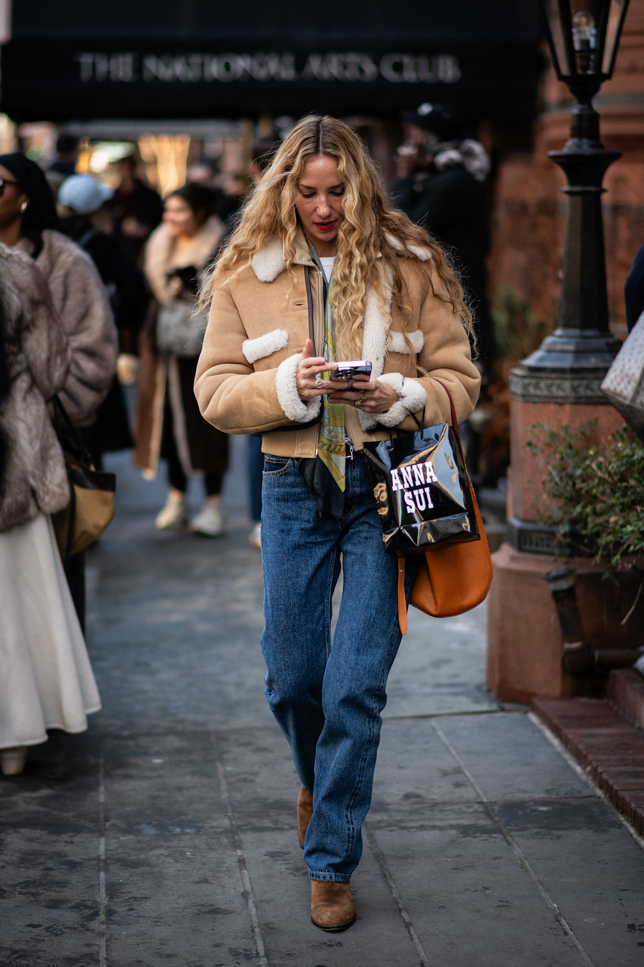 woman wearing shearling coat, jeans, and boots