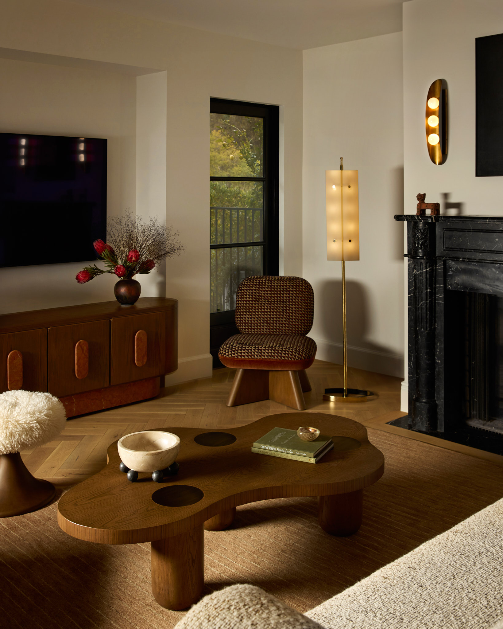Living room featuring Nina Takesh Furniture, including a chair, stool, sofa, and sculptural coffee table