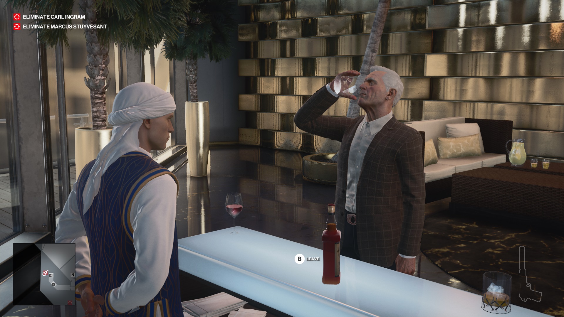 Hitman 3 - Agent 47 disguised in a penthouse servant uniform in the Dubai level standing behind a bar while Carl Ingram drinks from a whiskey glass.