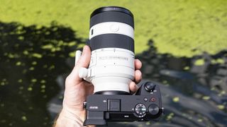 Sony FE 70-200mm F4 Macro G OSS II lens in the hand attached to Sony A6700