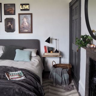 bedroom with white wall and cosy blacket on bed with lamp on bedside table