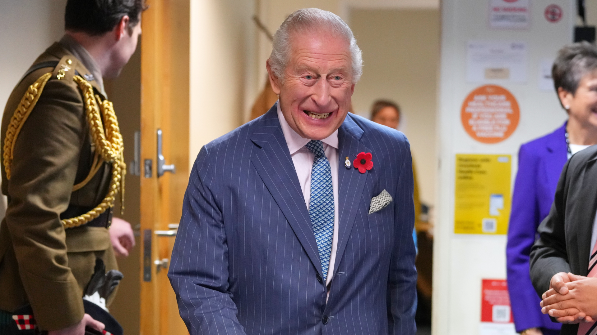 King Charles wearing a blue suit laughing