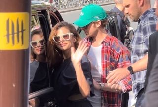 Eva Mendes wearing a navy blue knee-length dress with cream sunglasses and white pumps to the Olympics in Paris with husband Ryan Gosling.