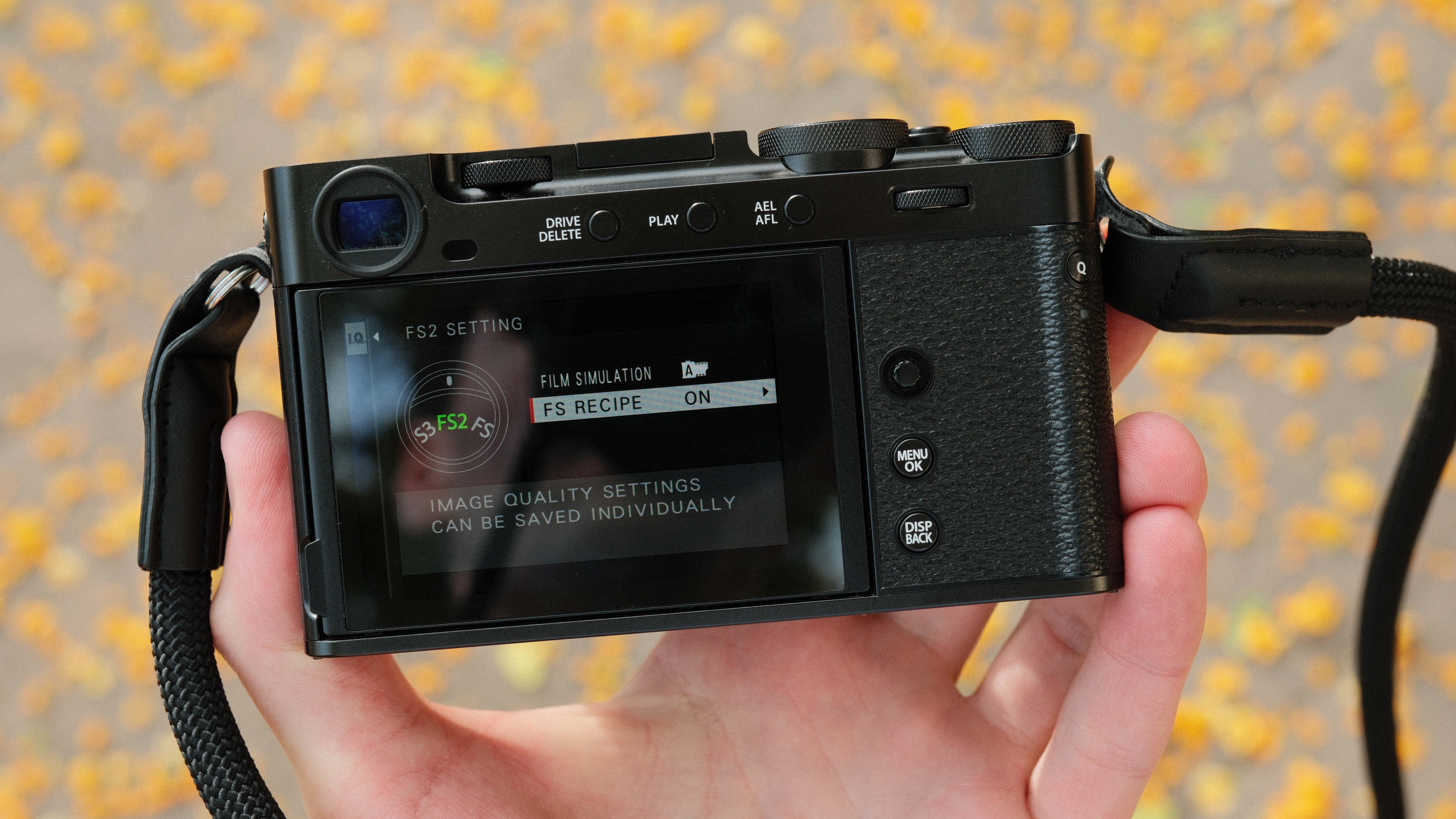 Fujifilm X-E5 camera held in a hand showing settings on the rear screen