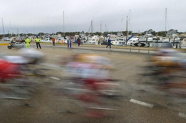 The peloton speed past moored boats in Paynesville in South Gippsland where the final stage of the tour was held.