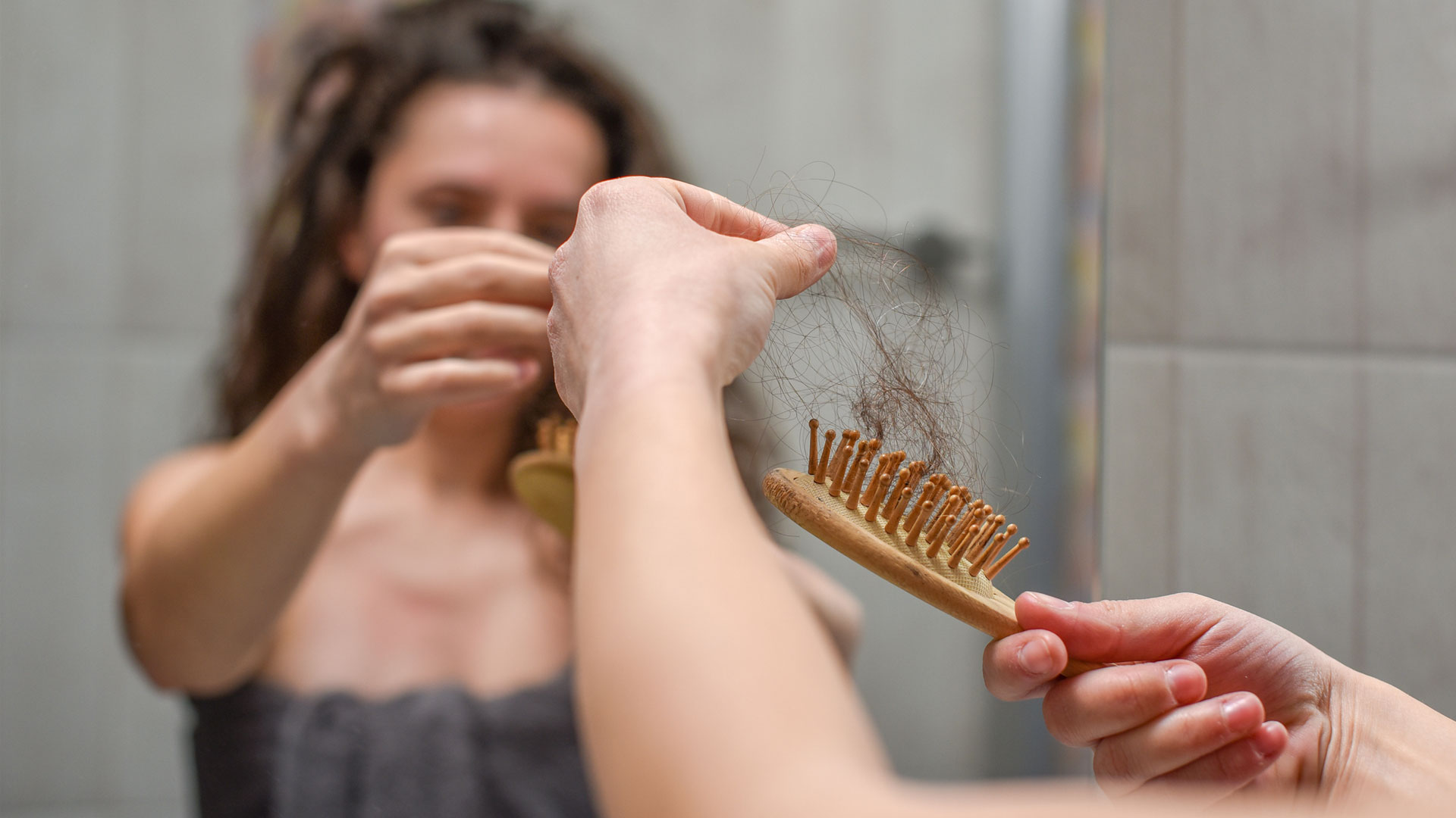 ¿El colágeno ayuda a que el cabello crezca?  la imagen muestra a una mujer con un cepillo para el cabello