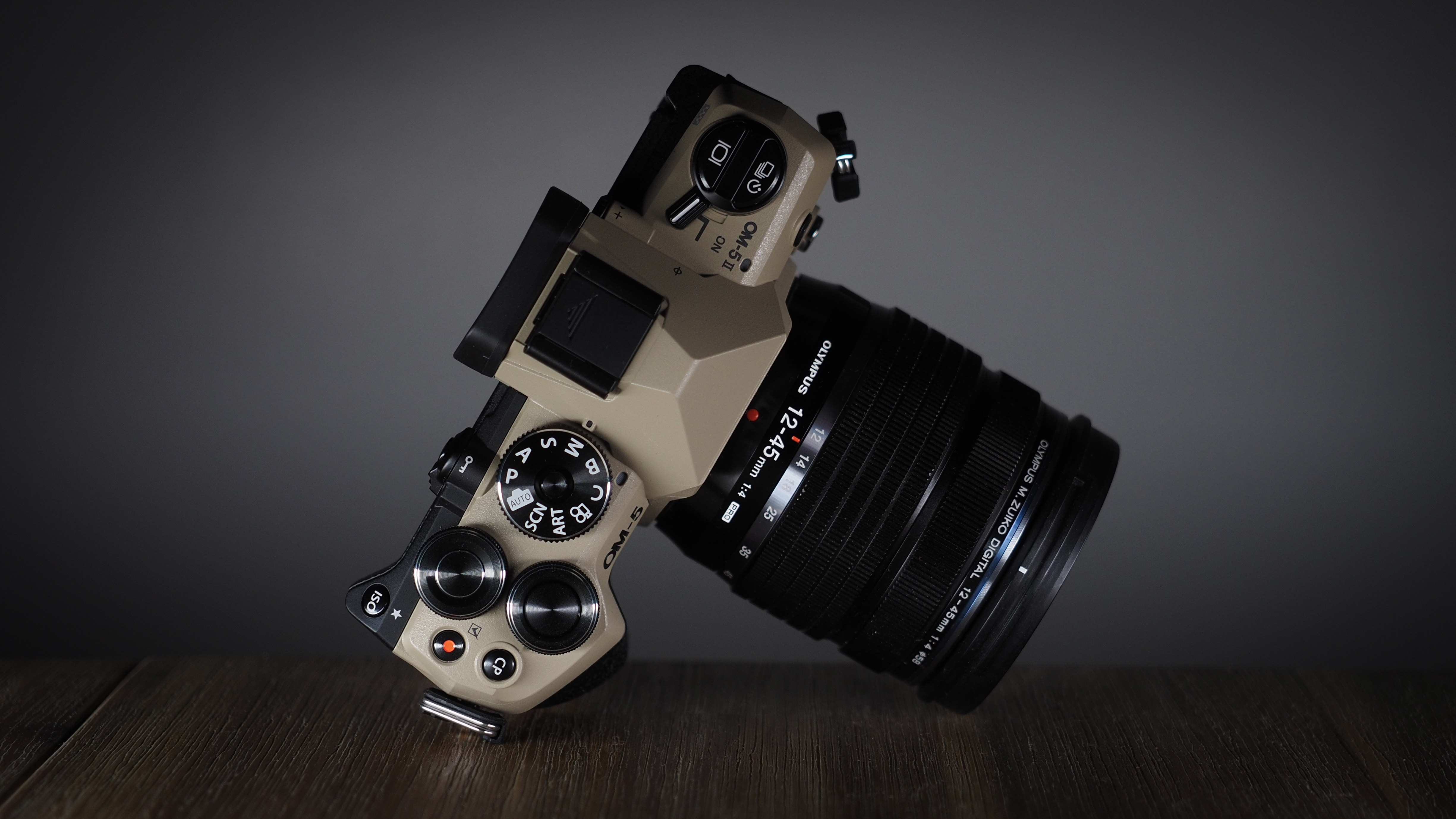 OM System OM-5 Mark II on a wooden surface with an Olympus M.Zuiko 12-45mm lens