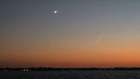 Landscape picture of a fireball in the sky over Lake Erie at sunset.