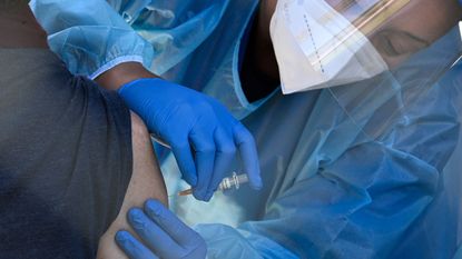 A flu vaccine is administered at a walk-up Covid-19 testing site, November 24, 2020, in San Fernando, California, just northeast of the city of Los Angeles. - California shattered the state's single-day COVID-19 record with over 20,500 new cases recorded on November 23 ahead of the Thanksgiving holiday. (Photo by Robyn Beck / AFP) / The erroneous mention appearing in the IPTC metadata of this photo by Robyn Beck has been modified in AFP systems in the following manner: [San Fernando, California] instead of [San Fernando, Philippines]. Please immediately remove the erroneous mention from all your online services and delete it from your servers. If you have been authorized by AFP to distribute it to third parties, please ensure that the same actions are carried out by them. Failure to promptly comply with these instructions will entail liability on your part for any continued or post notification usage. Therefore we thank you very much for all your attention and prompt action. We are sorry for the inconvenience this notification may cause and remain at your disposal for any further information you may require. (Photo by ROBYN BECK/AFP via Getty Images)