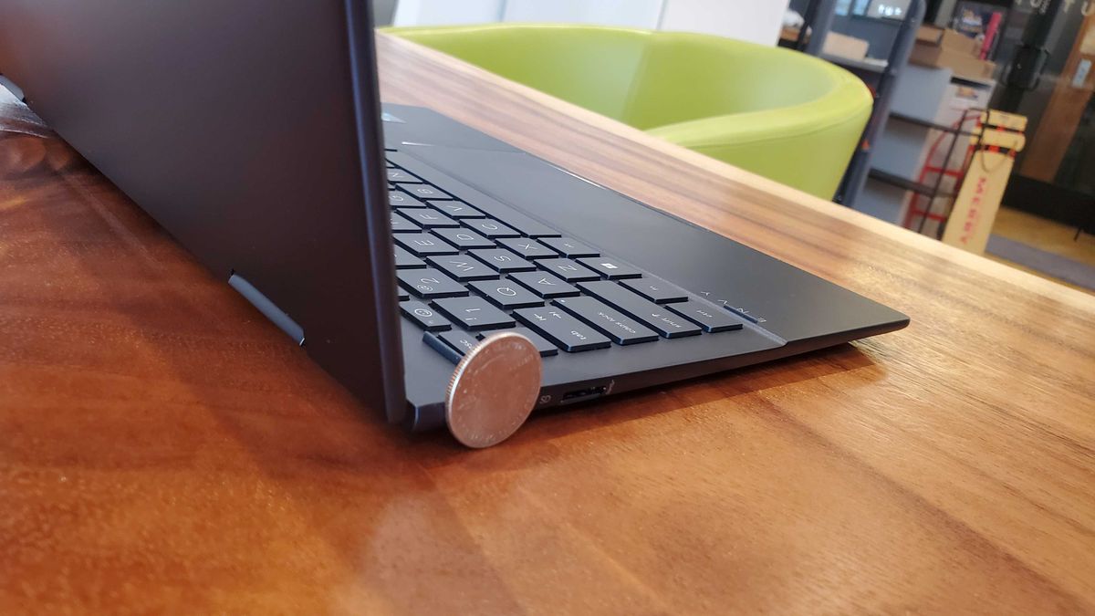 black laptop compared to a quarter
