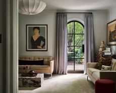 gray living room with arched window looking out to trees
