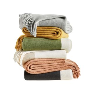 folded throw blankets in different colors on top of each other