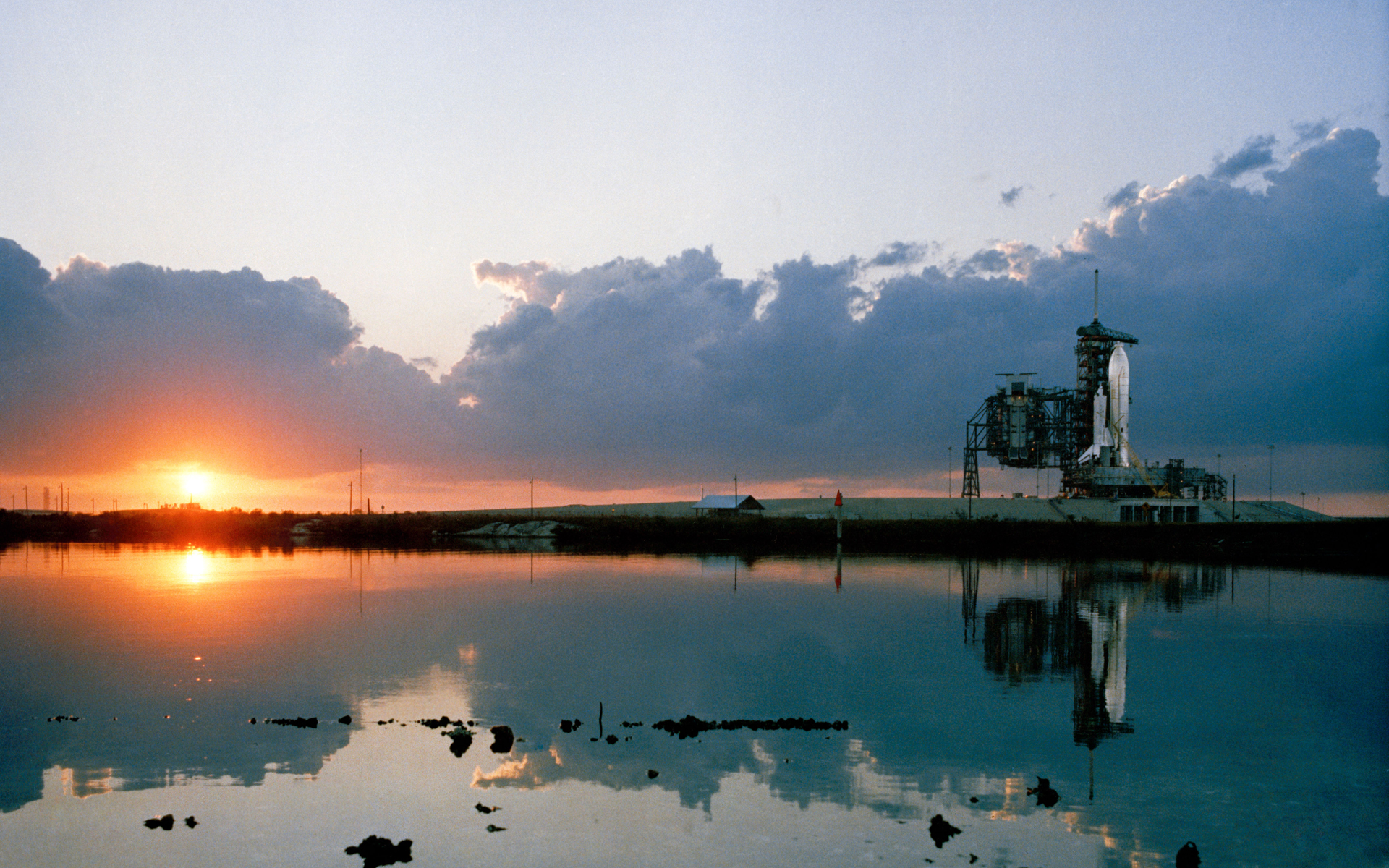 The sun rises over Kennedy Space Center as space shuttle Columbia awaits the start of STS-1, the first space shuttle mission, which launched on April 12, 1981.