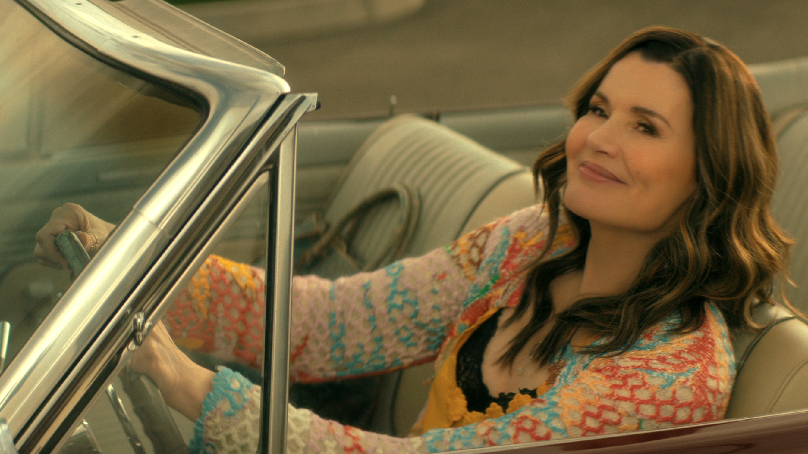 Geena Davis as Renee driving a car with the roof down in The Boroughs.